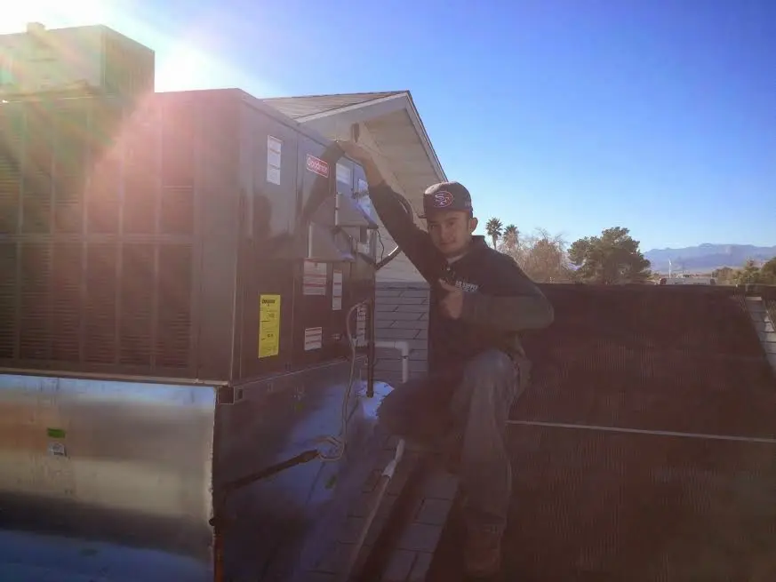 HVAC technician performing Air Duct Cleaning on a rooftop unit in Princeton